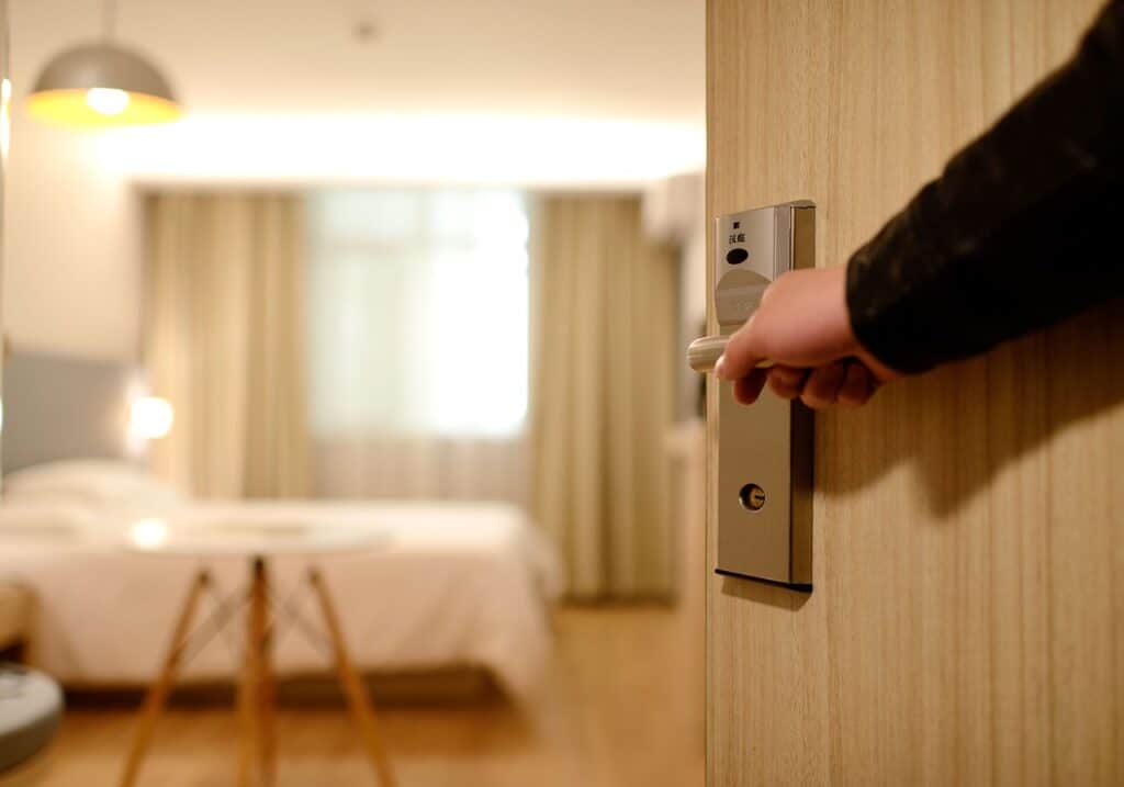 An arm opening a door to a room at one of the Columbia South Carolina hotels near airport.