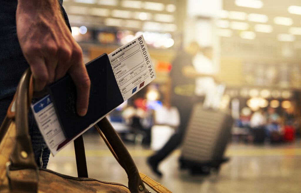 A hand with a boarding pass holding a bag after spending a night at a Columbia SC airport hotel.