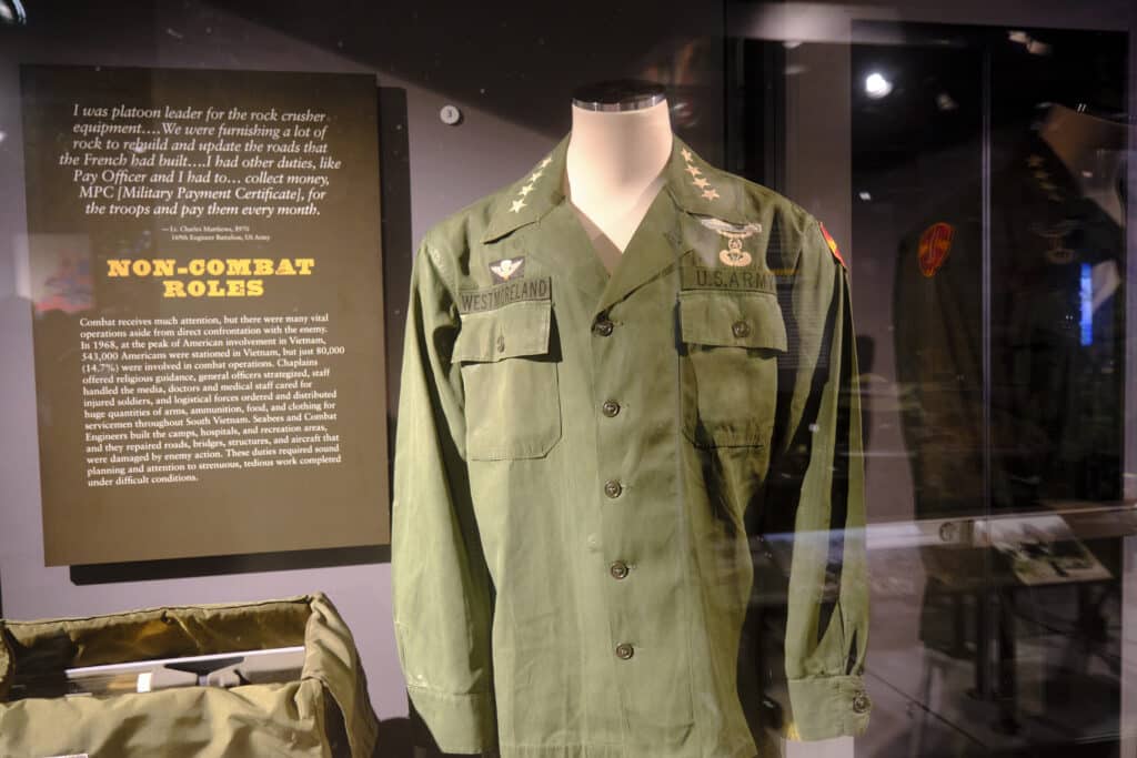 Photo of a uniform in a display in the military museum in Columbia, SC with a board that says non combat roles. The uniform says Westmoreland on the right breast.