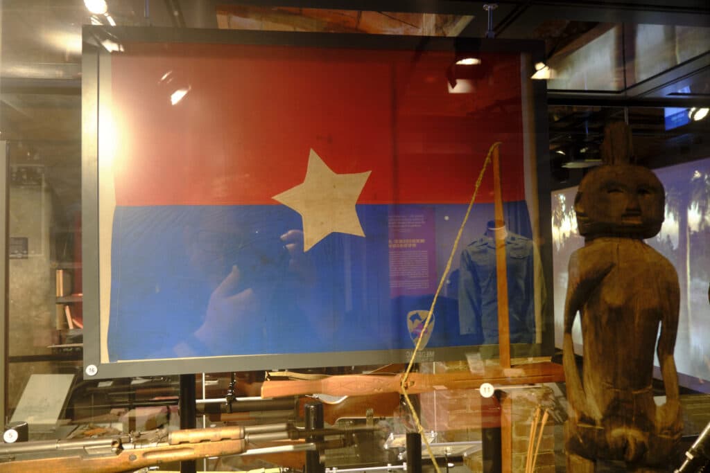 Artifacts at the SC Confederate Museum and Military Museum showing a Vietcong flag and some rifles with a statue.