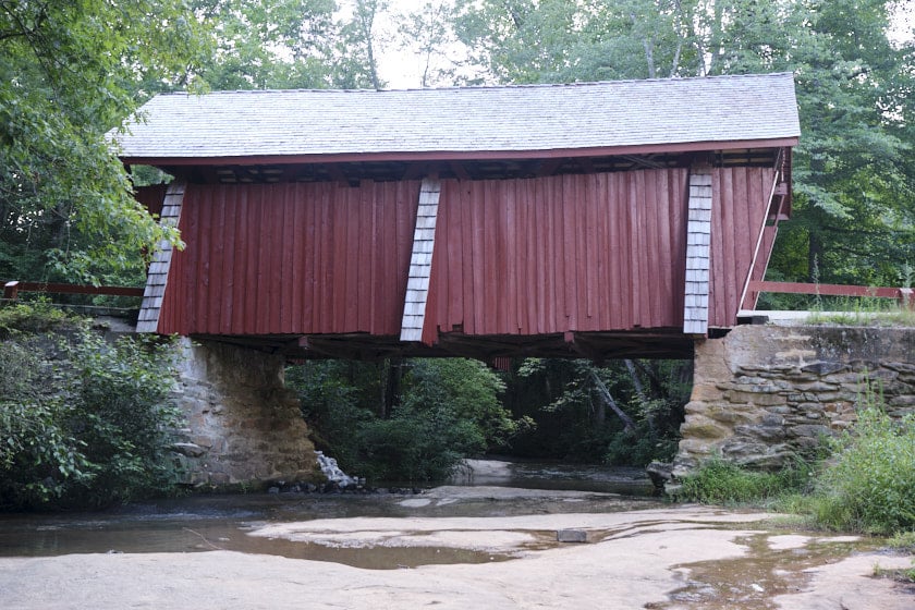 View of the Campbell's Covered Bridge over a shallow and rocky creek.