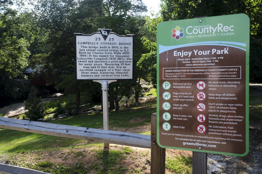 Photo of a historic markers titled Campbell's Covered Bridge and a Greenville CountyRec sign explaining the rules of the park.