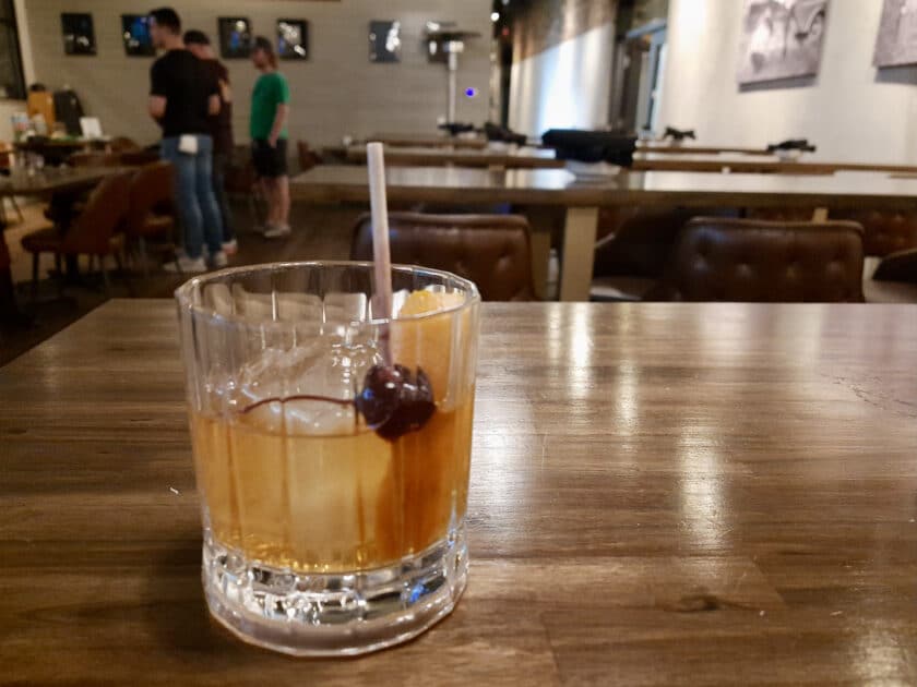 An old fashioned on a table with people in the background at the Columbia Steel Hands downtown location.