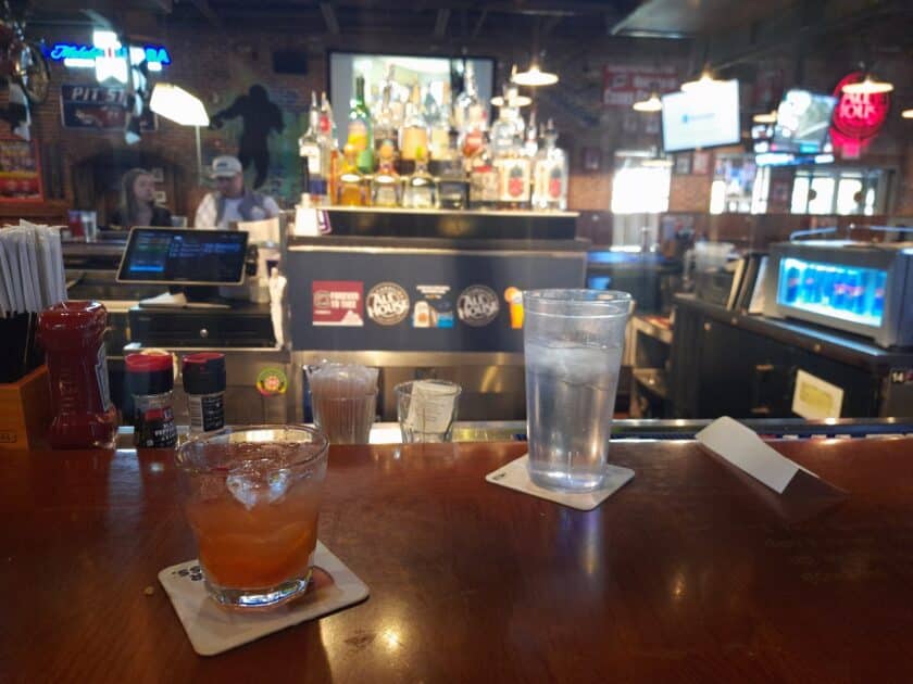 A cocktail sitting next to a water on the bar at Carolina Ale House in Columbia, SC.