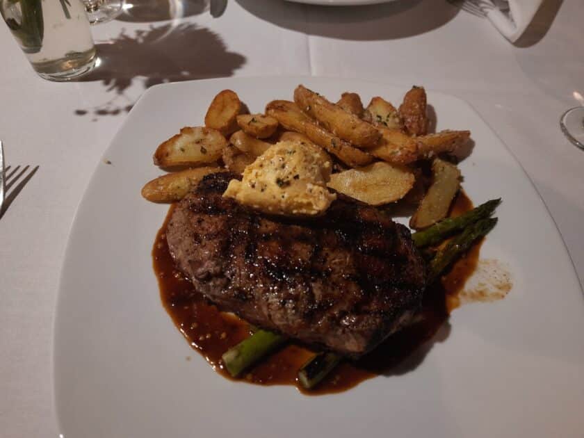 A steak with potatoes and asparagus on a plate at Saluda's Restaurant in Columbia, SC.