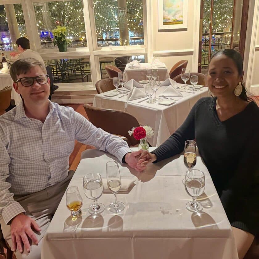 A couple sitting at a table holding hands at Saluda's Restaurant in Columbia, SC.